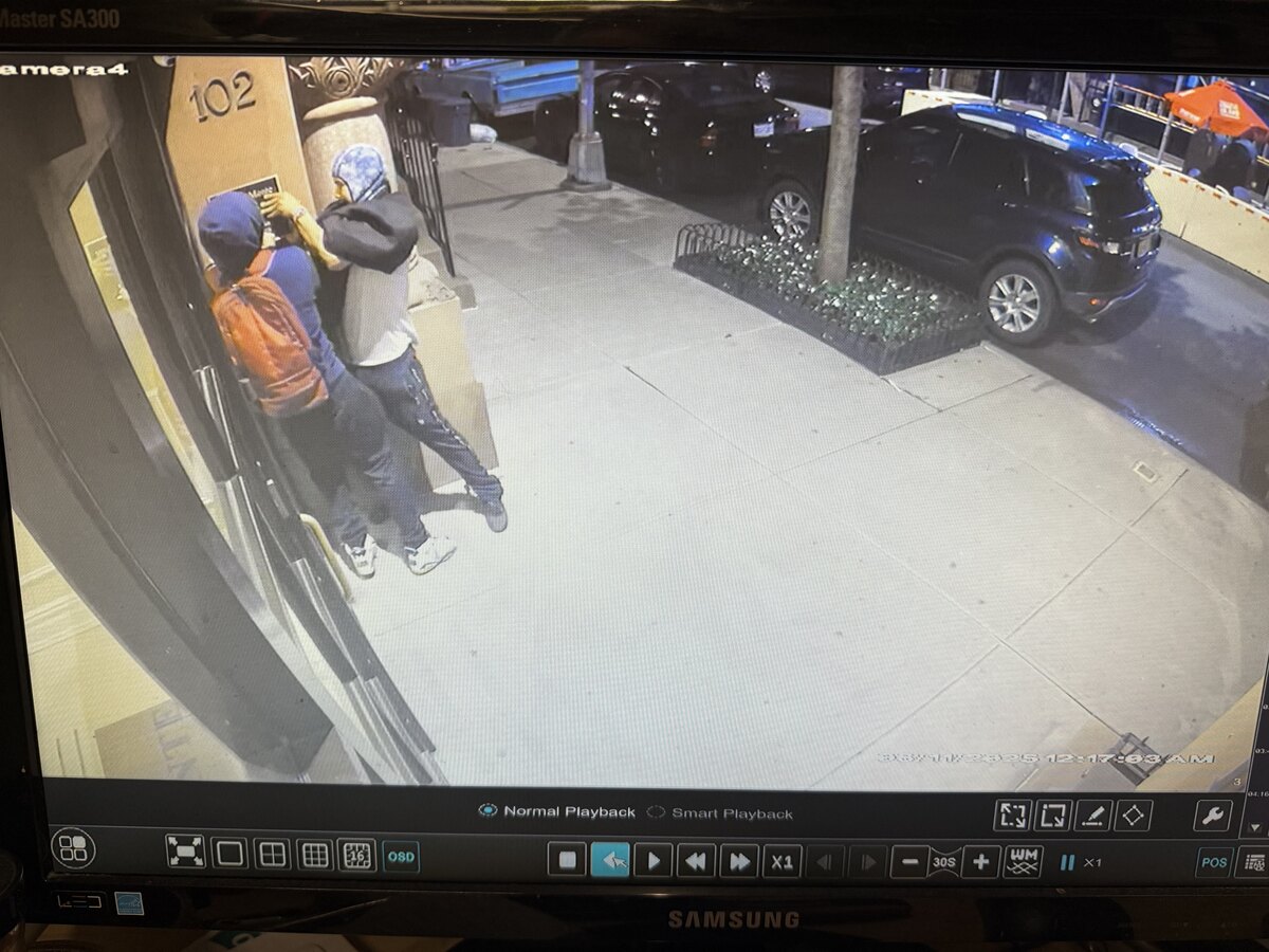 men removing plaque from bldg